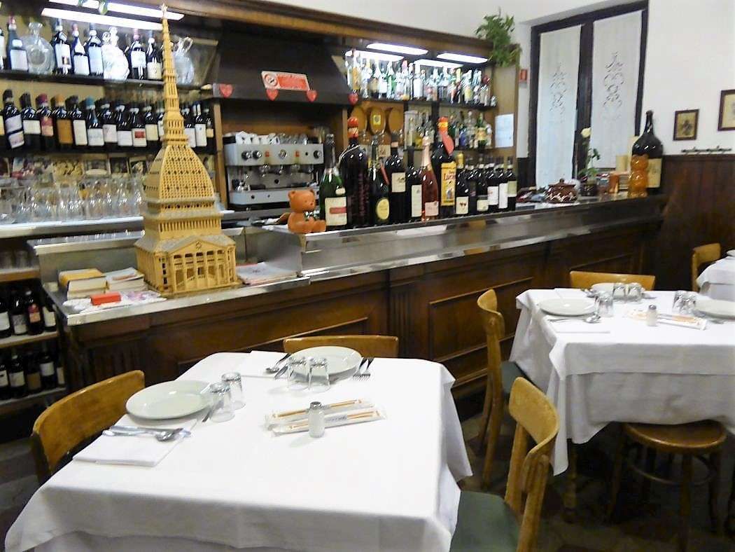 Il banco del bar con bottiglie e un modellino della Mole Antonelliana