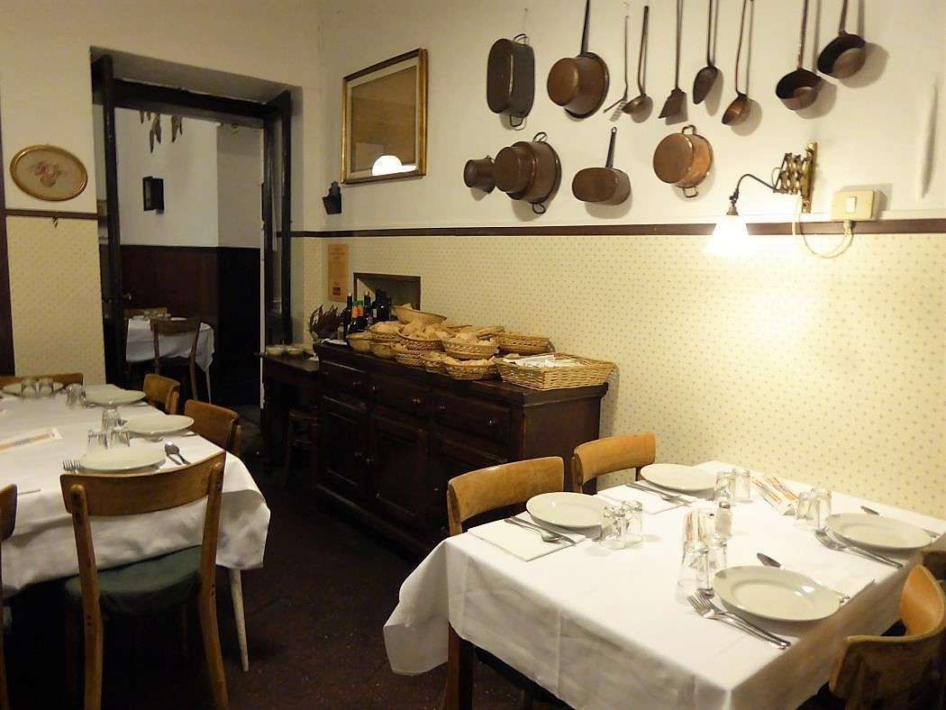 Saletta con pentole di rame appese e una credenza con cestini di pane